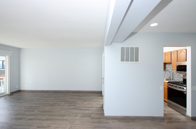 interior space featuring baseboards, visible vents, light wood-style floors, a sink, and recessed lighting