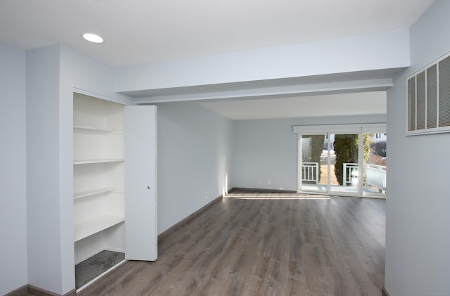 interior space featuring dark wood-type flooring, visible vents, and baseboards