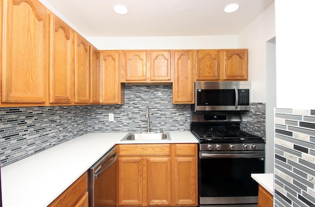 kitchen with stainless steel appliances, backsplash, a sink, and light countertops