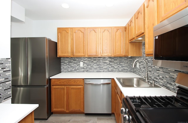 kitchen with a sink, stainless steel appliances, and light countertops