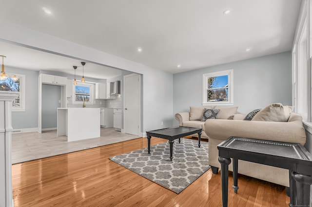 living area with light wood-style flooring, baseboards, and recessed lighting