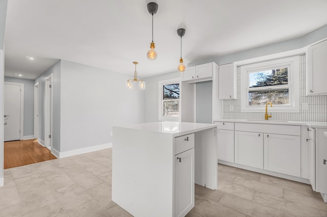 kitchen with a kitchen island, a wealth of natural light, a sink, and tasteful backsplash