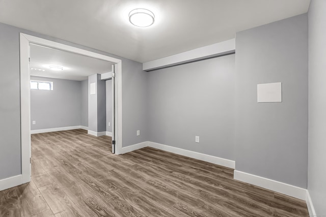 below grade area with dark wood-style flooring and baseboards