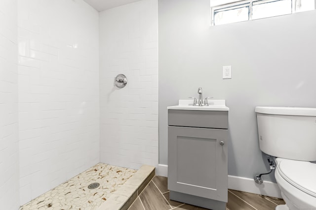 full bath featuring a stall shower, baseboards, vanity, and toilet