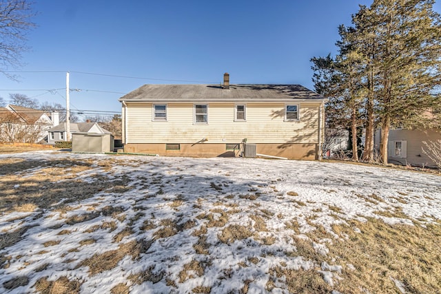 snow covered property with central AC unit