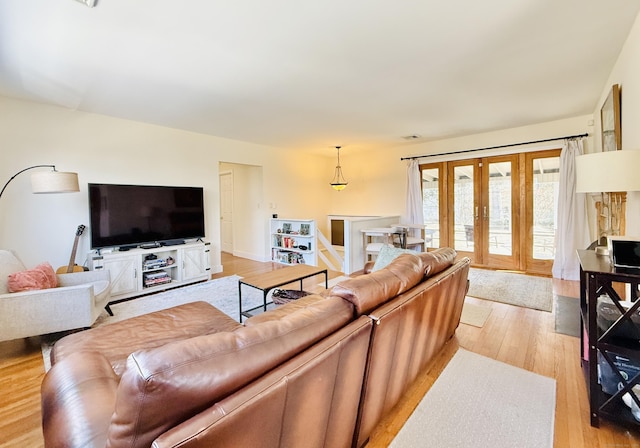 living area with visible vents, french doors, and light wood-style flooring