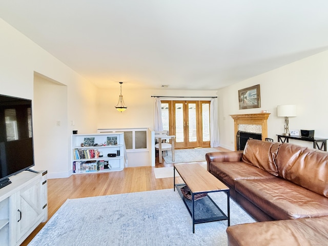 living room featuring visible vents, a fireplace, light wood-style flooring, and baseboards