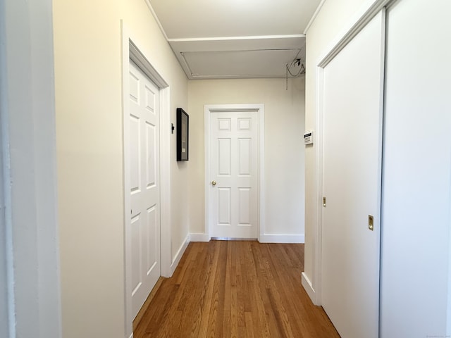 hall with baseboards and wood finished floors