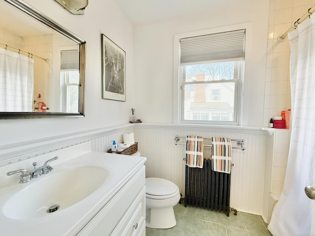 full bath featuring a wainscoted wall, radiator heating unit, vanity, a shower with curtain, and tile patterned floors