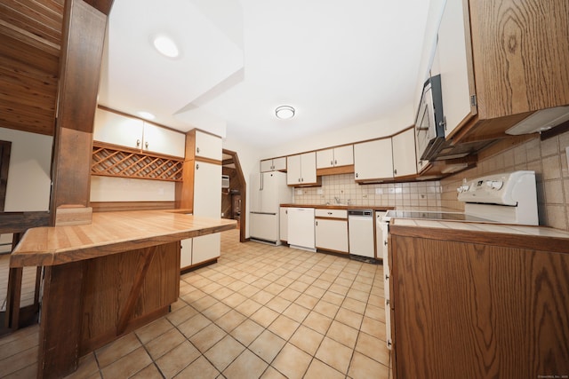 kitchen featuring white appliances, light tile patterned floors, tile counters, white cabinets, and backsplash