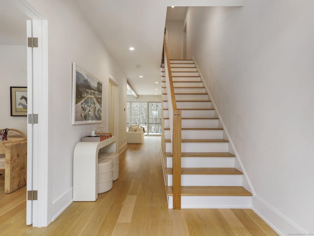 stairs with recessed lighting, wood finished floors, and baseboards