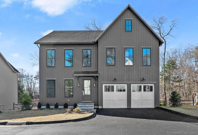 view of front of house featuring aphalt driveway, roof with shingles, and a garage