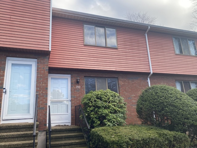 view of front of property with entry steps and brick siding