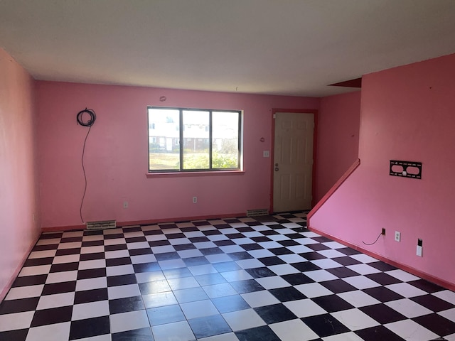 spare room with light floors, visible vents, and baseboards