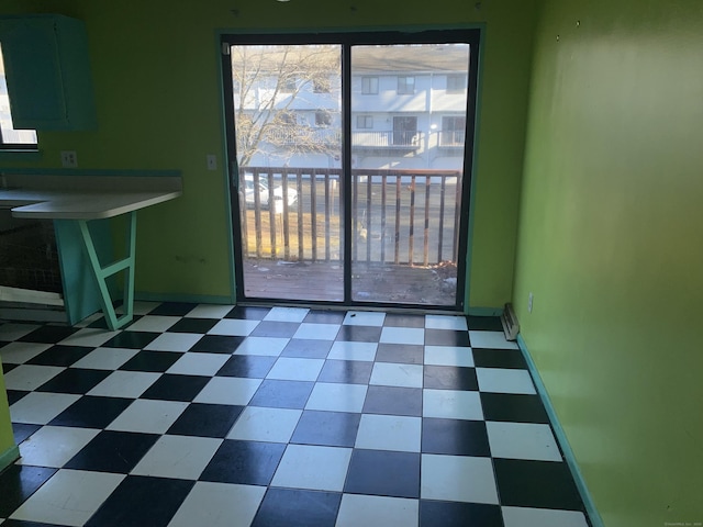 unfurnished dining area with baseboards and tile patterned floors