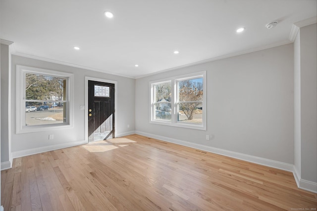 entrance foyer with crown molding, light wood-style flooring, and baseboards