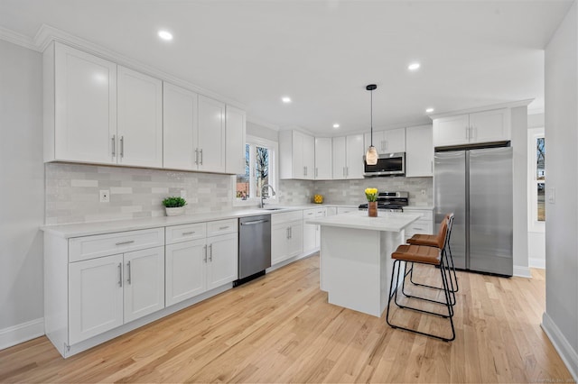 kitchen featuring appliances with stainless steel finishes, light countertops, and white cabinetry