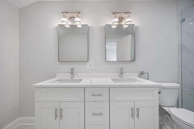 bathroom with double vanity, a sink, toilet, and baseboards