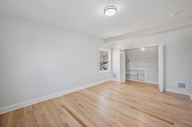 unfurnished bedroom with light wood-type flooring, baseboards, and visible vents