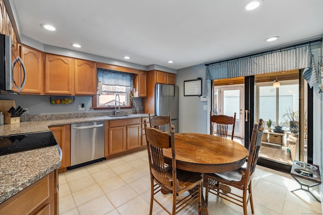 kitchen featuring appliances with stainless steel finishes, recessed lighting, brown cabinetry, and a sink