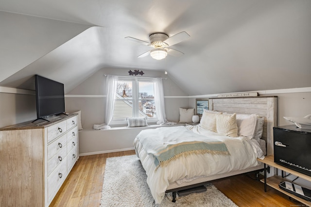 bedroom with light wood finished floors, baseboards, vaulted ceiling, and a ceiling fan