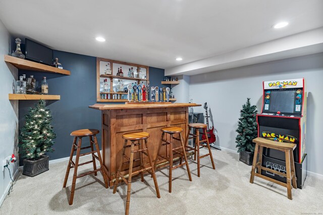 bar featuring light carpet, indoor bar, recessed lighting, and baseboards