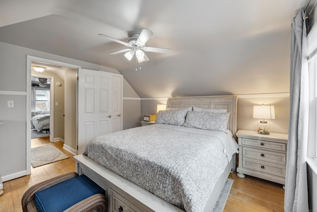 bedroom with light wood-type flooring, ceiling fan, lofted ceiling, and baseboards