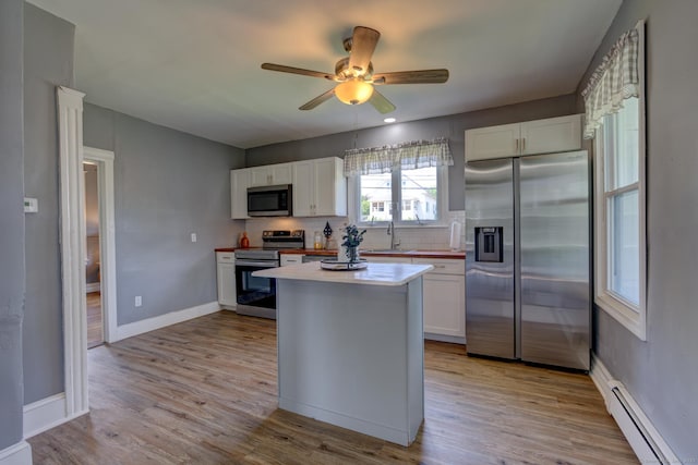 9 Crown St, Middletown, CT 06457 - kitchen featuring appliances with stainless steel finishes, baseboard heating, white cabinets, tasteful backsplash, and ceiling fan