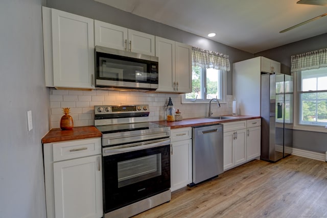 9 Crown St, Middletown, CT 06457 - kitchen featuring appliances with stainless steel finishes, butcher block counters, light wood-style floors, backsplash, and white cabinets