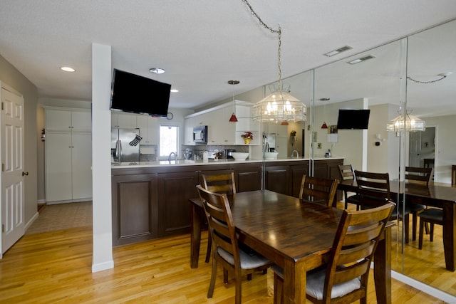 dining space featuring light wood-style floors and visible vents