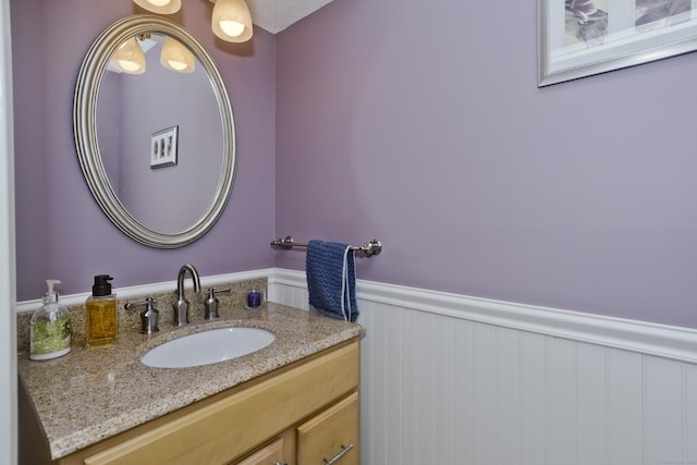 bathroom featuring a wainscoted wall and vanity