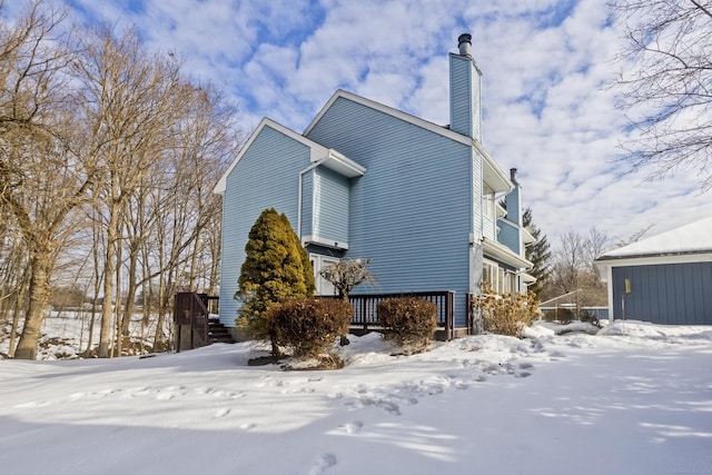 snow covered property with a chimney