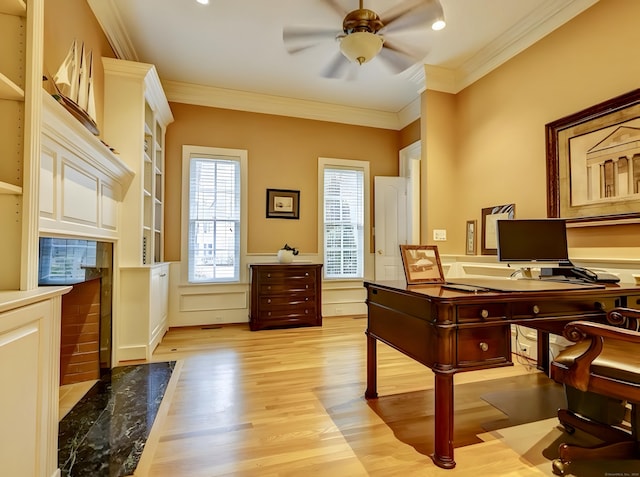 office area with crown molding, light wood-style floors, a wainscoted wall, and ceiling fan