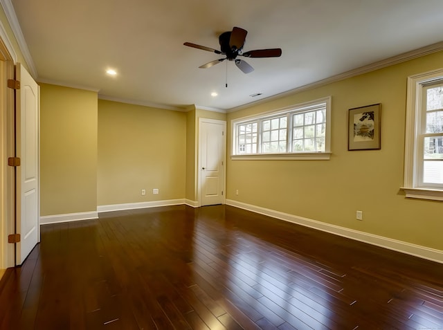 unfurnished room with a ceiling fan, dark wood-type flooring, crown molding, and baseboards