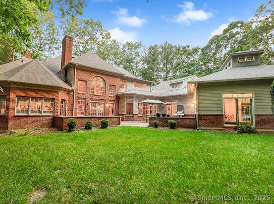 1 Wentworth Park, Farmington, CT 06032 - rear view of house featuring a chimney, brick siding, a lawn, and a patio