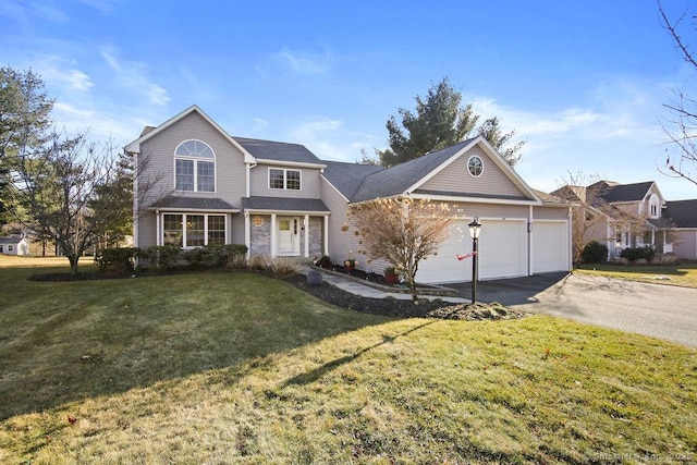 traditional home featuring aphalt driveway, a garage, and a front yard