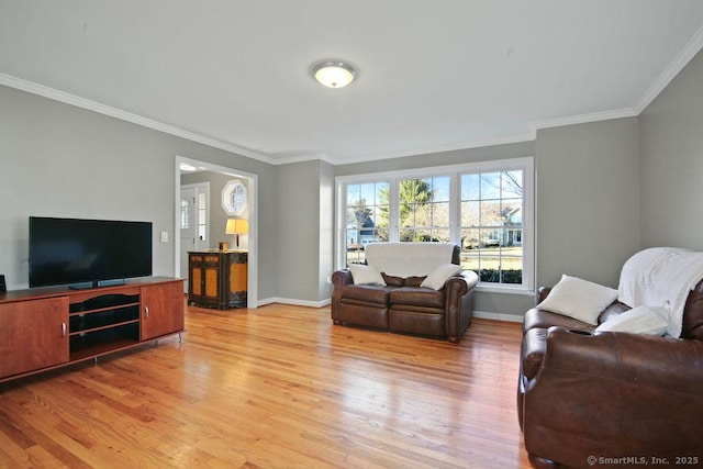 living area featuring baseboards, light wood-type flooring, and ornamental molding