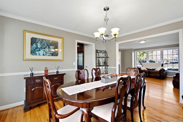 dining room with light wood-type flooring, a chandelier, and ornamental molding