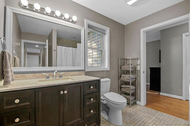 bathroom with tile patterned floors, toilet, vanity, and baseboards