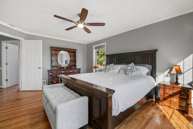 bedroom featuring crown molding, a ceiling fan, and wood finished floors