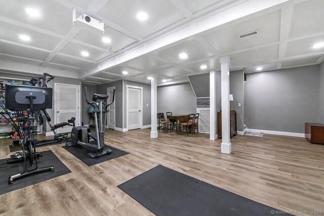 workout room featuring wood finished floors, baseboards, and coffered ceiling