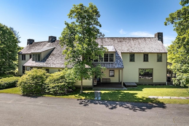 tudor house featuring a front lawn and a chimney