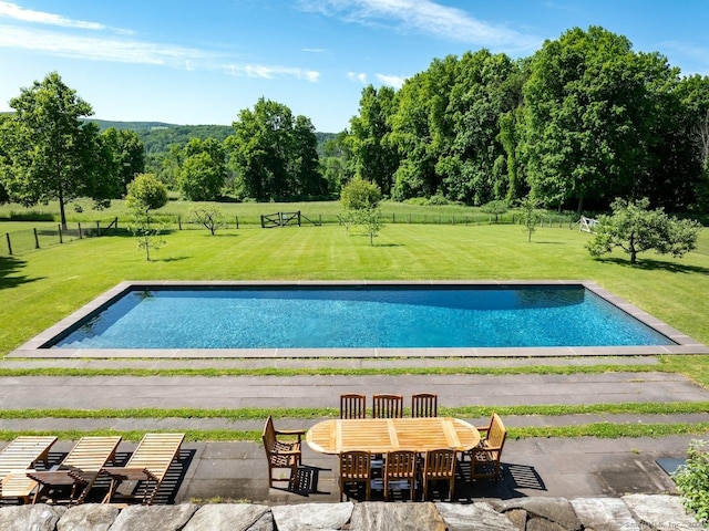 outdoor pool with a lawn and fence