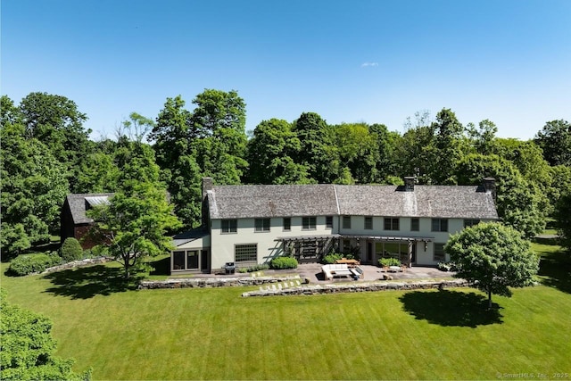 back of property with a chimney, a patio, a lawn, and a pergola