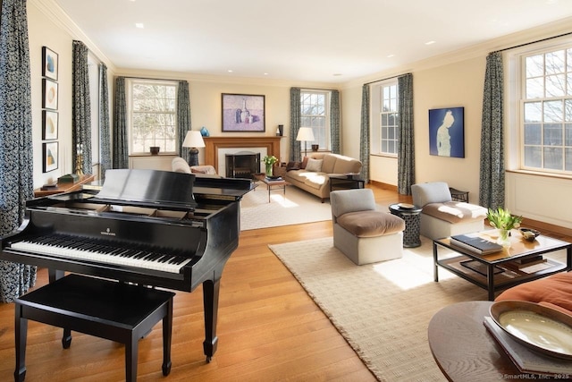 sitting room with ornamental molding, a fireplace, and a healthy amount of sunlight