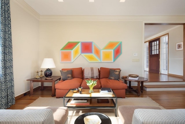 living area featuring crown molding, baseboards, and wood finished floors