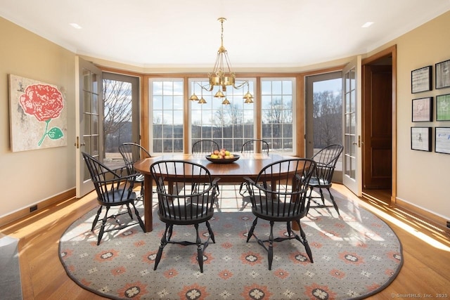 dining room featuring baseboards, wood finished floors, and a healthy amount of sunlight