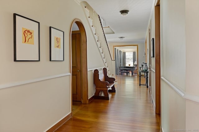 hall with baseboards, stairway, and wood finished floors