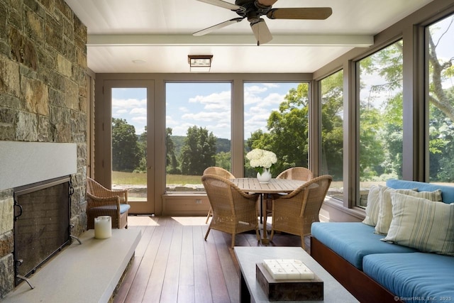 sunroom / solarium with beamed ceiling, a fireplace, and a healthy amount of sunlight