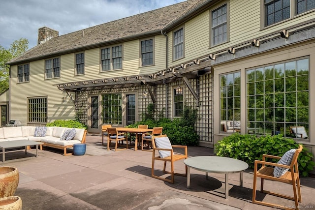 rear view of property featuring a patio area, a chimney, outdoor lounge area, and a pergola